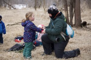 Teacher helping student with mitten